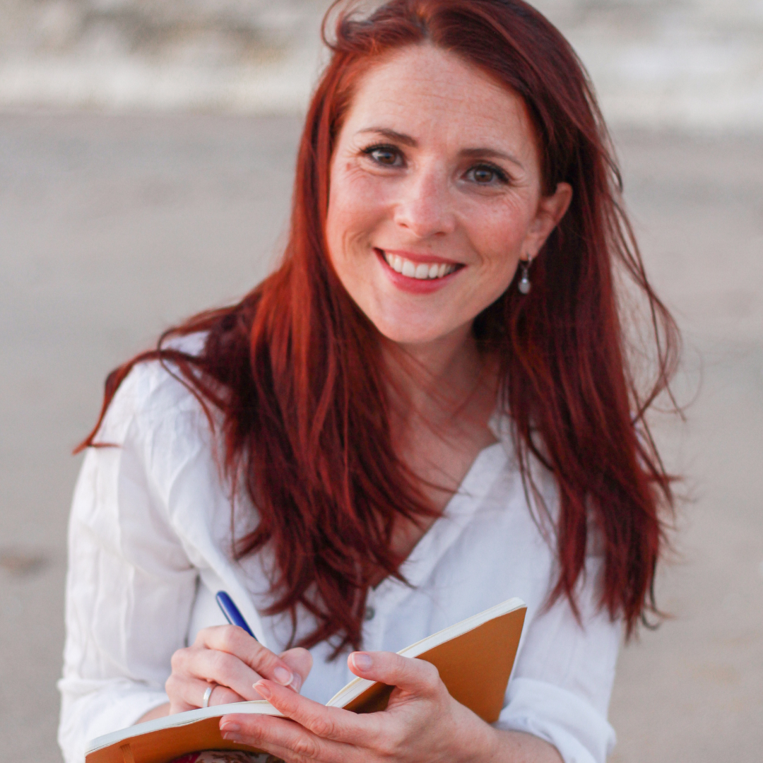 Charlotte TREMEL assise sur la plage, écrivant sur un carnet, symbolisant un moment de réflexion et de création pour les entrepreneurs et professionnels artistiques.