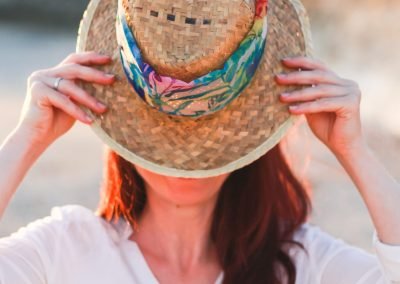 Une femme portant un grand chapeau, cachant son visage, symbolisant l'incertitude et le parcours de découverte de soi dans l'entrepreneuriat. Son posture montre une force intérieure prête à se révéler. Charlotte Tremel tous droits réservés