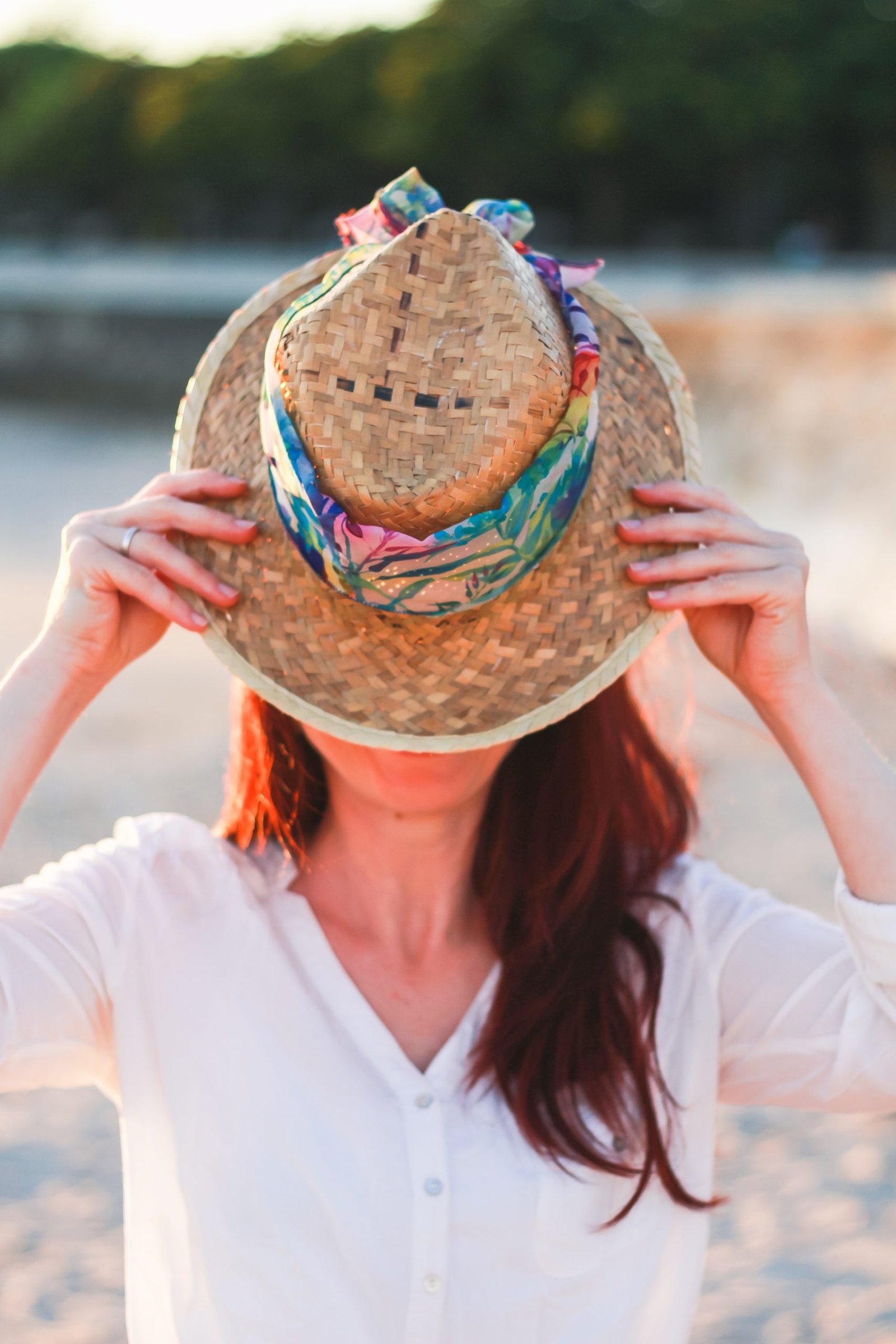Une femme portant un grand chapeau, cachant son visage, symbolisant l'incertitude et le parcours de découverte de soi dans l'entrepreneuriat. Son posture montre une force intérieure prête à se révéler. Charlotte Tremel tous droits réservés