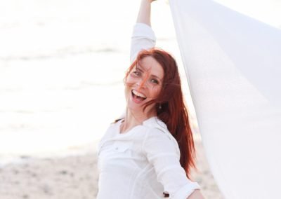 Photo de Charlotte Tremel, pleine de vie et de joie sur la plage, représentant le processus de reconnexion à soi et de transformation à travers le coaching Tremplin. monter une entreprise
