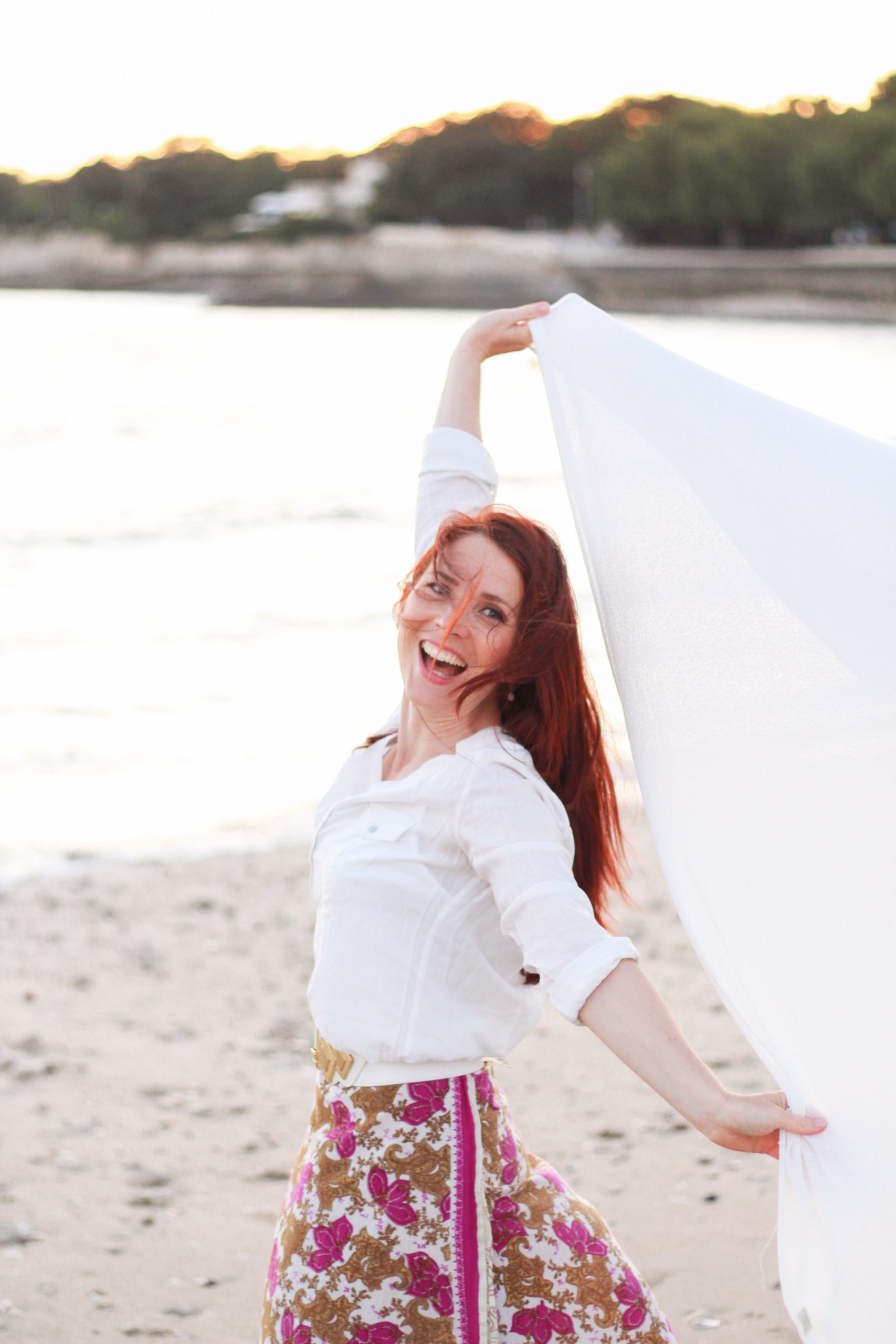 Photo de Charlotte Tremel, pleine de vie et de joie sur la plage, représentant le processus de reconnexion à soi et de transformation à travers le coaching Tremplin. monter une entreprise