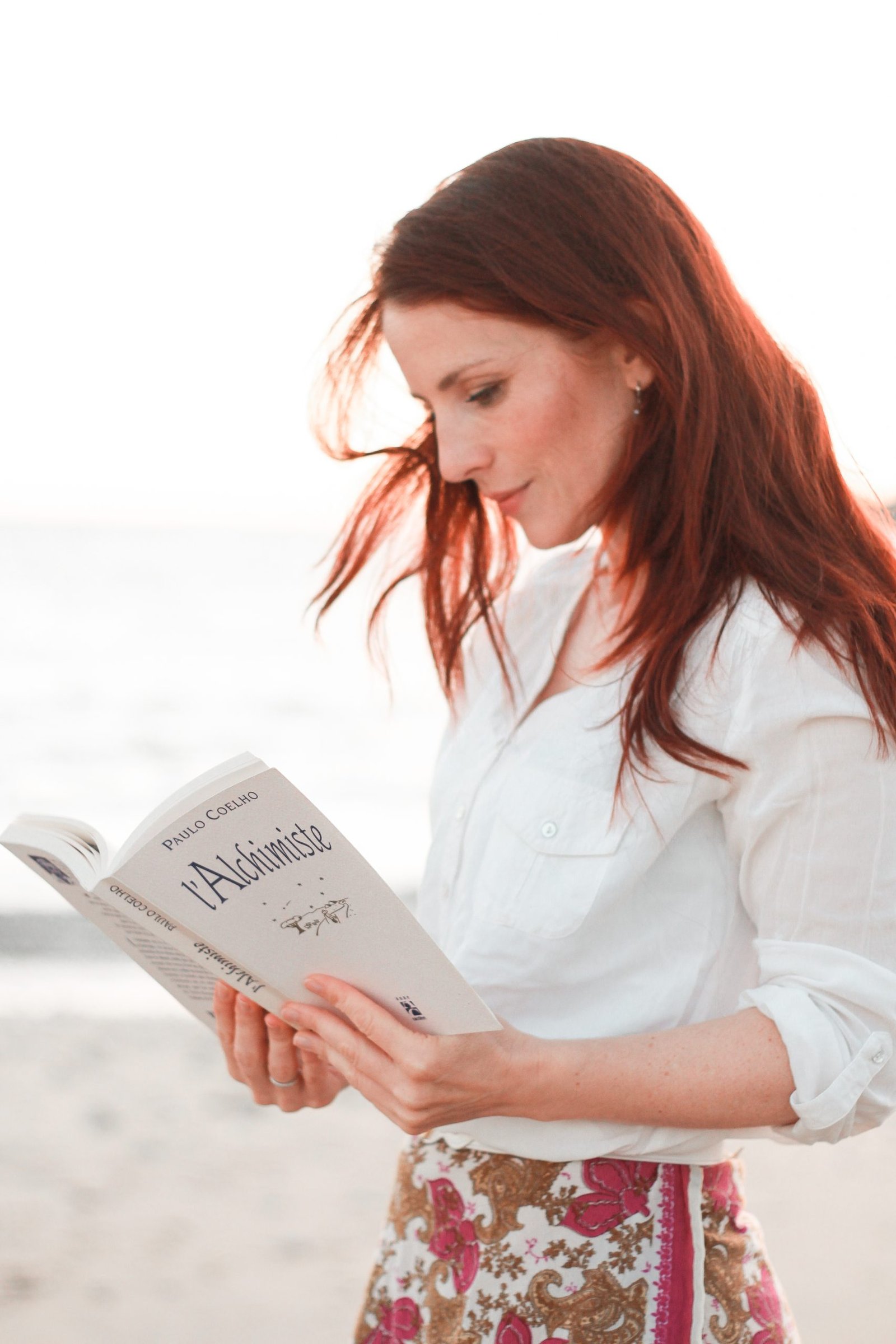  Image de la coach en train de lire L'Alchimiste, symbole de la quête intérieure et de la transformation durable à travers le coaching. Charlotte TRMEL (tous droits réservés)